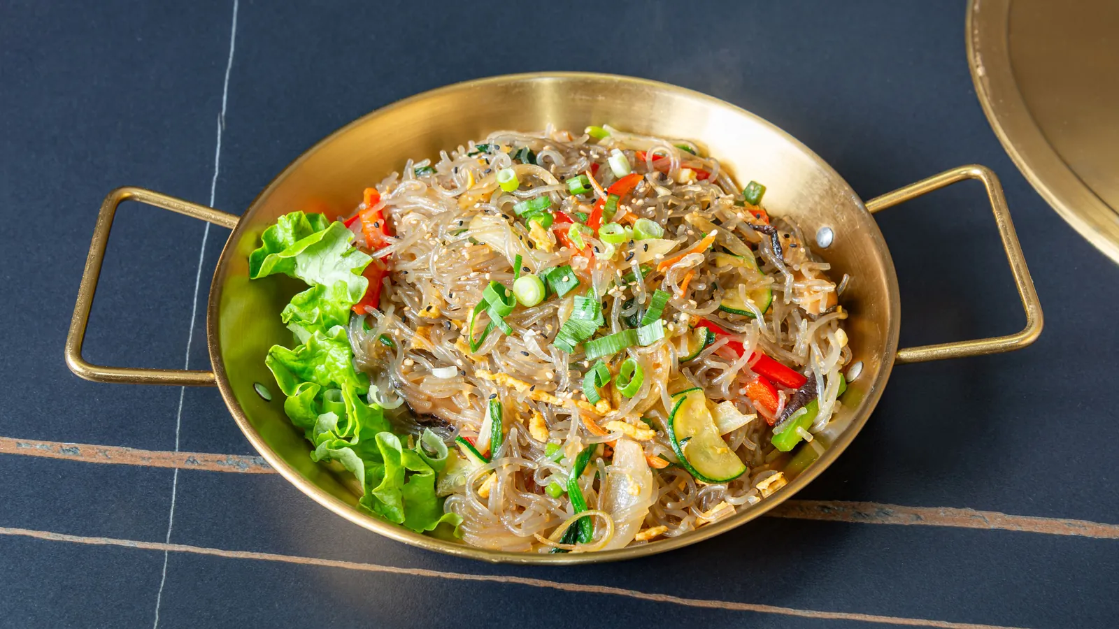 Vermicelles de patate douce sautées aux légumes, dans une poêle dorée