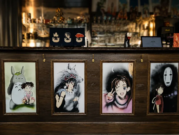 Le comptoir Mikoro avec quatre toiles manga encadr&eacute;es align&eacute;es sur sa face avant