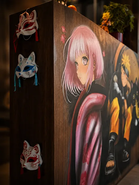 Masques de renard japonais accroch&eacute;s pr&egrave;s de la fresque manga