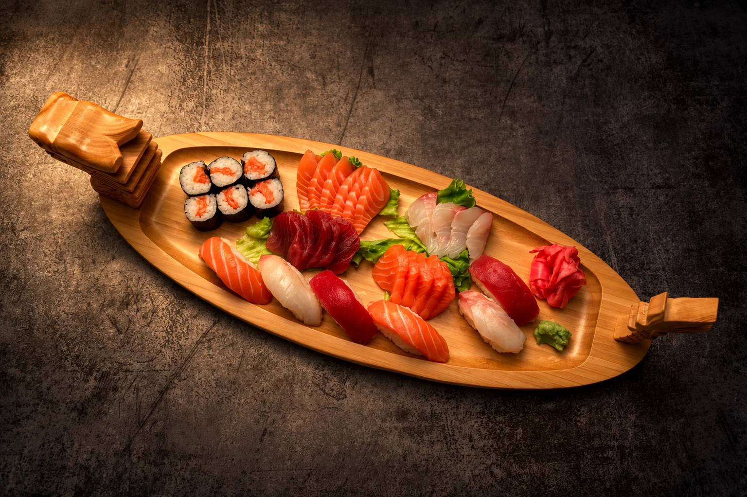 Sushis, makis et sashimis dans un plateau en bois en forme de bateau, lumière tamisée.