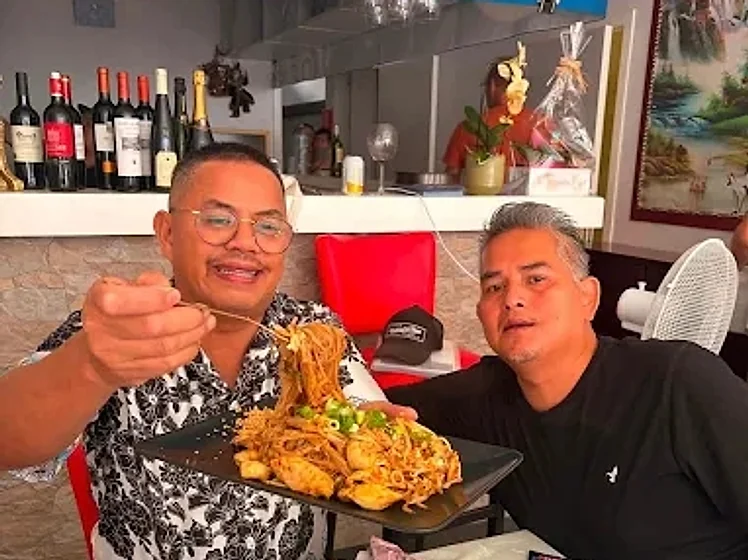 Twee gasten delen een noedelgerecht bij Thaï Korat Restaurant