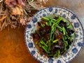 Champignons noirs sautés avec jeunes pousses d’ail